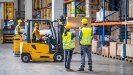 Forklift in warehouse with workers